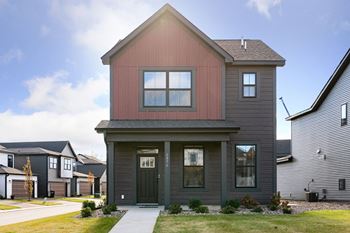 the front of a house with a sidewalk in front of it